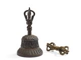 une vieille cloche en bronze et une clé sur fond blanc