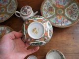 a person holding a cup and saucer on a table