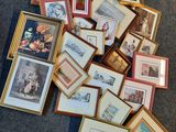 une pile de photos encadrées posées par terre dans une pièce