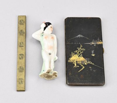 une petite figurine représentant une femme debout à côté d'une règle