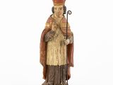 a wooden statue of a man with a cane and a robe