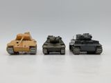three toy tanks sitting side by side on a white surface