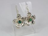 a pair of silver earrings with green stones on them