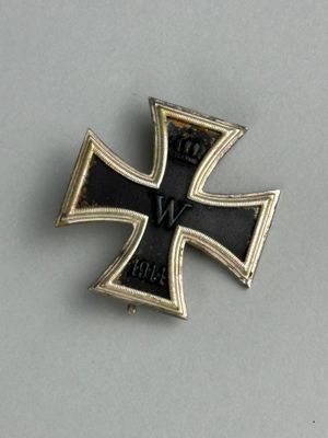 une broche en forme de croix de fer, ornée d'une croix noire et dorée