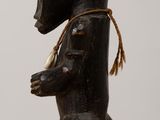 a small wooden statue of a bear with a hat on
