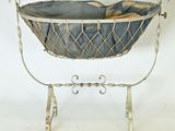 a baby basket with a blanket in it on a stand