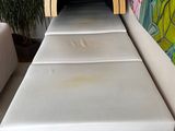 a bed that is made out of wood and has a white sheet on it