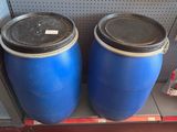 two blue barrels sitting on a shelf next to each other