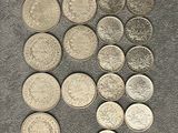 a close up of a pile of silver coins on a table
