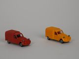 deux petites voitures posées côte à côte sur une surface blanche