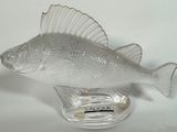 un poisson en verre posé sur un socle en verre