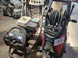 deux nettoyeurs haute pression dans un garage où des outils traînent par terre