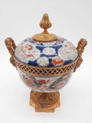 un vase bleu et blanc avec un couvercle doré