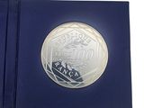 l'image d'une pièce d'argent dans une boîte bleue sur fond blanc