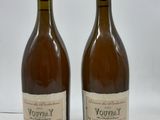 deux bouteilles de vin posées l'une à côté de l'autre sur une surface blanche