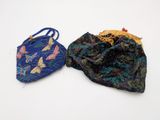 two small purses sitting next to each other on a white surface