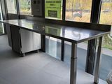une table au milieu d'une pièce, avec une poubelle devant