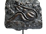 bronze sculpture of a lizard on a rock with a white background