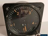 a small black analog clock on a white table