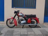 a red motorcycle parked in front of a building