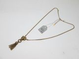 a close up of a necklace on a white surface with a tag