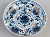 blue and white plate with floral designs on it on a gray surface