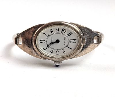 une image d'un gros plan d'une montre-bracelet sur une surface blanche