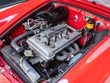 a red car with a small engine in it ' s trunk