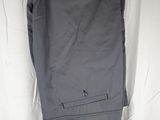 a pair of gray pants hanging on a hanger on a wall