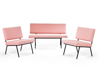 trois chaises roses et un canapé dans une pièce au fond blanc