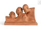 a sculpture of three people laying on a bed
