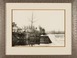 a black and white photo of a man riding a skateboard over a bridge