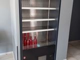 une photo d'un réfrigérateur dans une cuisine, rempli de bouteilles