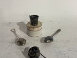 a few spoons and a cup on a table