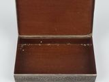 an old wooden box with a metal handle on a white surface