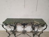 a marble top table with wrought iron legs
