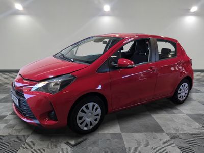 une Toyota Yaris rouge garée sur un sol à damier
