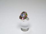 ring with multicolored stones in a clear glass vase