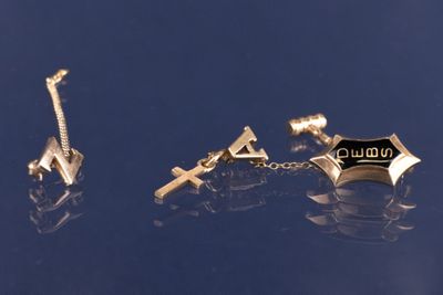 deux paires de boutons de manchette et une croix sur un fond bleu