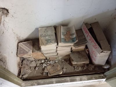 une pile de livres posée par terre dans un coin de la pièce