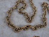 a gold chain that is laying on a table