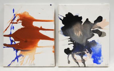 two paintings of different colors are on a white surface