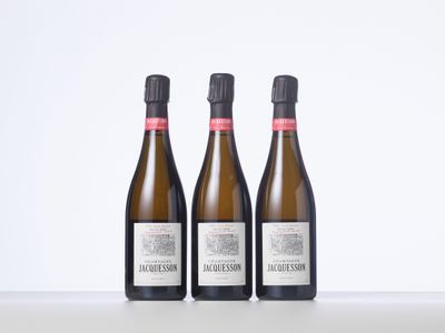 trois bouteilles de vin posées sur une table l'une à côté de l'autre