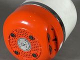 an orange and white speaker sitting on a gray surface