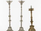 a pair of silver candlesticks and a candle holder