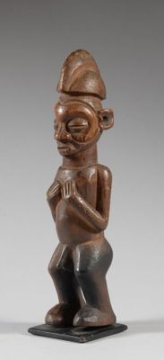une figurine en bois représentant un homme avec un chapeau sur la tête