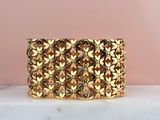 a close up of a gold bracelet on a marble surface