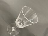 two empty wine glasses sitting on a table next to each other