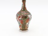 a small vase with a red and green design on it