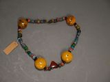 necklace made of wooden beads and glass beads with a tag on it